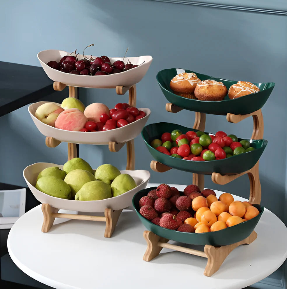 Multi-tiered fruit and dessert display stand with various fruits and pastries on a neutral background.