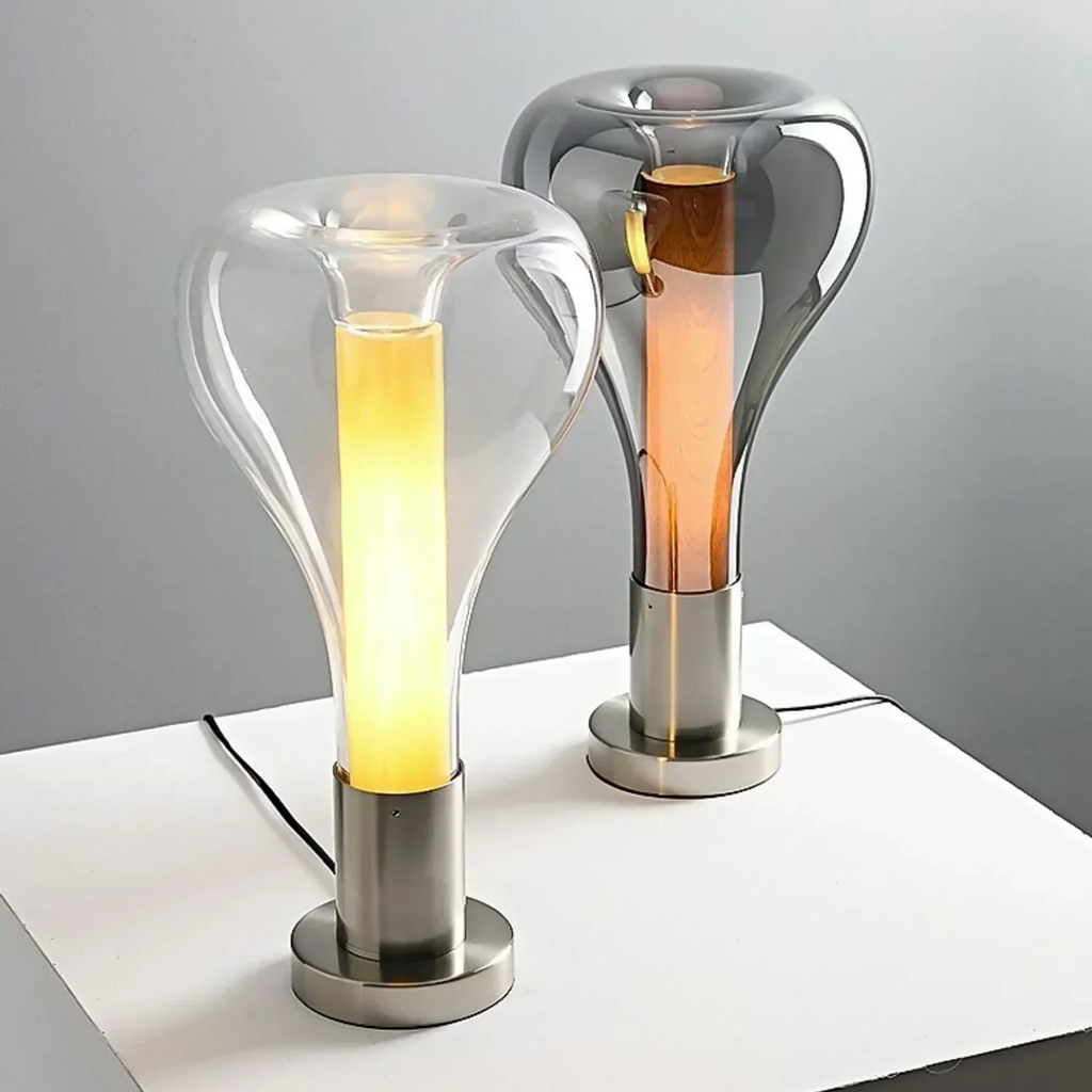 Two modern table lamps with glass shades on a white surface.