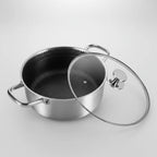 Stainless steel pot with a glass lid on a light gray background
