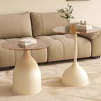 Two modern side tables with round tops and cylindrical bases in a living room setting.
